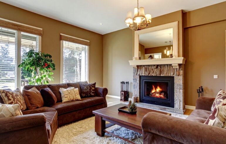 Bright open-plan living room with white linen sofas, sheer curtains, and natural light flooding in through tall windows.