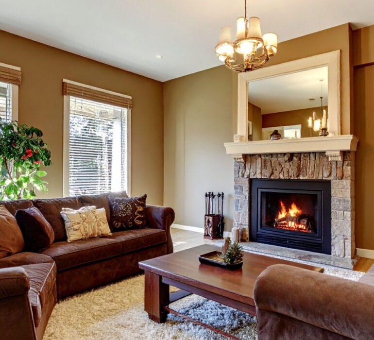 Bright open-plan living room with white linen sofas, sheer curtains, and natural light flooding in through tall windows.